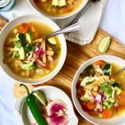 soup in white bowls with various toppings