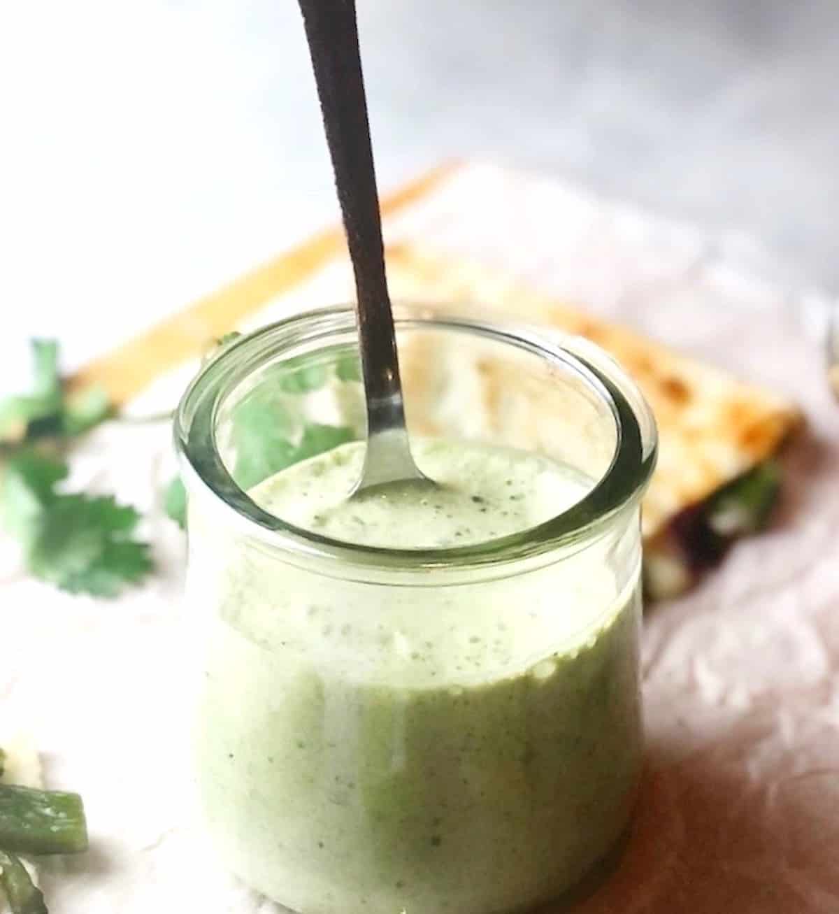 Poblano sauce in jar with spoon.