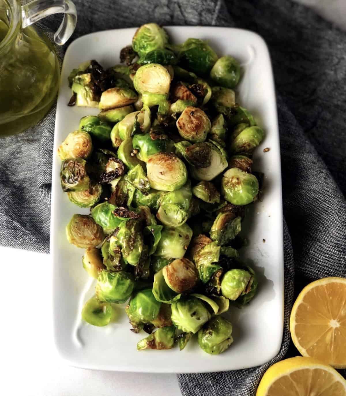 cooked Brussels sprouts on a plate with lemon