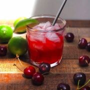 Homemade cherry limeade in a glass with ice.