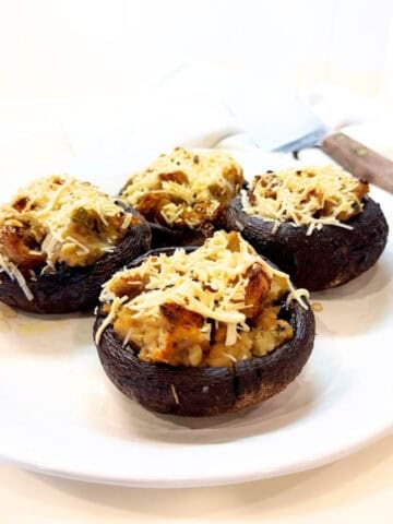Stuffed portobello mushrooms with stuffing on a plate.