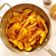 Golden potatoes with turmeric in a large saute pan.