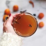 Mulled cider in a cup being held by a person.