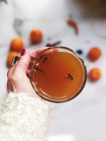 Mulled cider in a cup being held by a person.