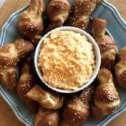 Beer cheese dip on a plate with soft pretzels.