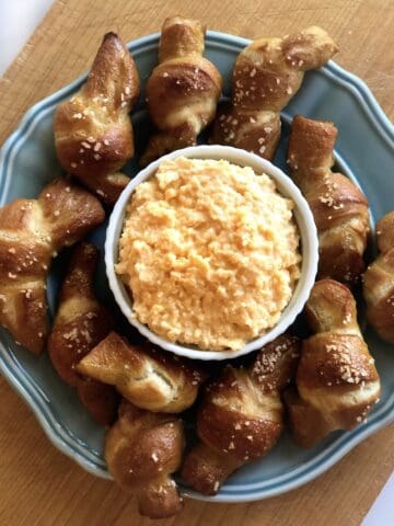 Beer cheese dip on a plate with soft pretzels.