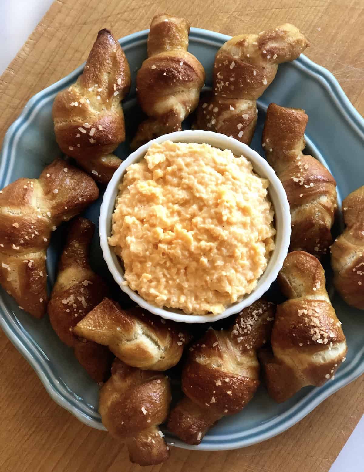 Beer cheese dip on a plate with soft pretzels.