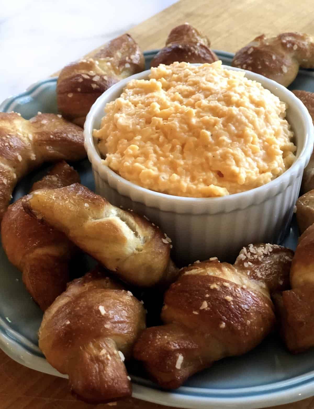 Pretzel knots on a plate with beer cheese dip.
