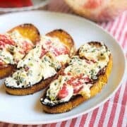 Goat cheese and red pepper spread on top of crostini.