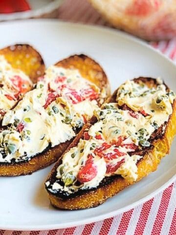 Goat cheese and red pepper spread on top of crostini.