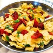 Roasted tomato and raviolini pasta in a large pan.