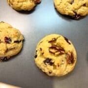 Cranberry and pecan cookies on a baking sheet.
