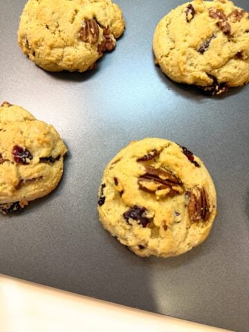Cranberry and pecan cookies on a baking sheet.