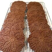 Chocolate pizzelle on wire cooling rack.