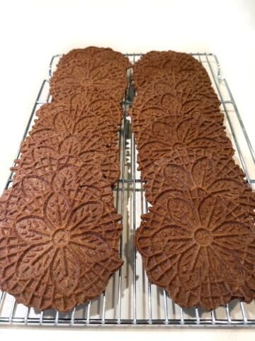 Chocolate pizzelle on wire cooling rack.